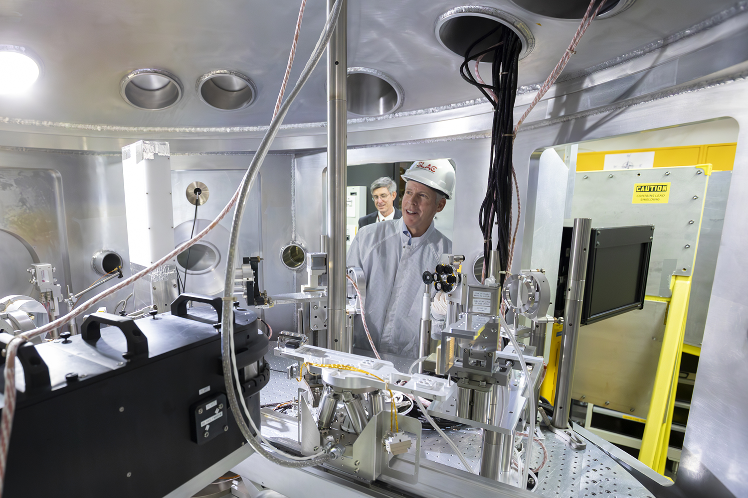 Image of Secretary of Energy Chris Wright examining equipment at SLAC.